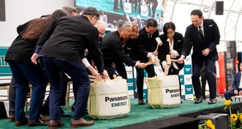 Business and community leaders gather on stage for a traditional Japanese ceremony — Kagami Biraki, or a sake barrel opening — as part of the Grand Opening Ceremony for Panasonic Energy's new EV battery facility in De Soto, KS.