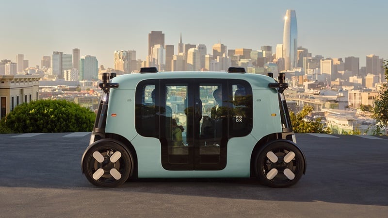 Exterior side view of a Zoox robotaxi carrying 3 passengers